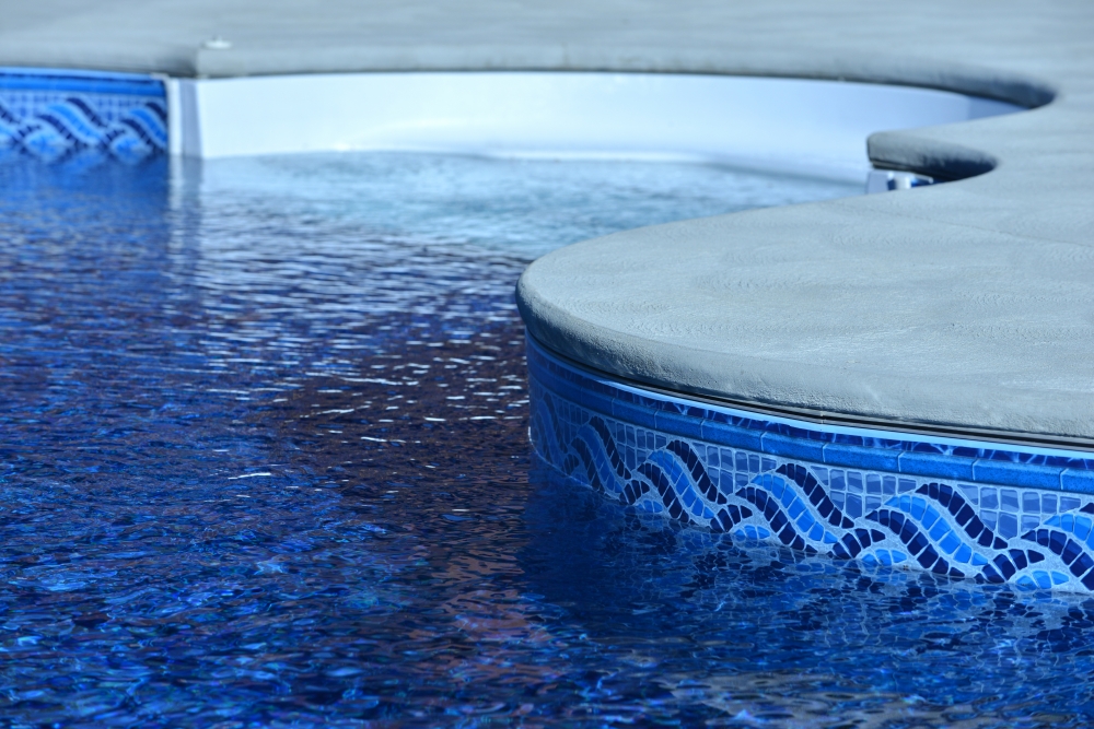 Pool tile and coping Austin project: technicians resetting waterline tile and limestone coping